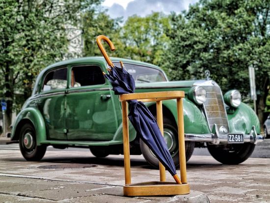 umbrella in front of an old car